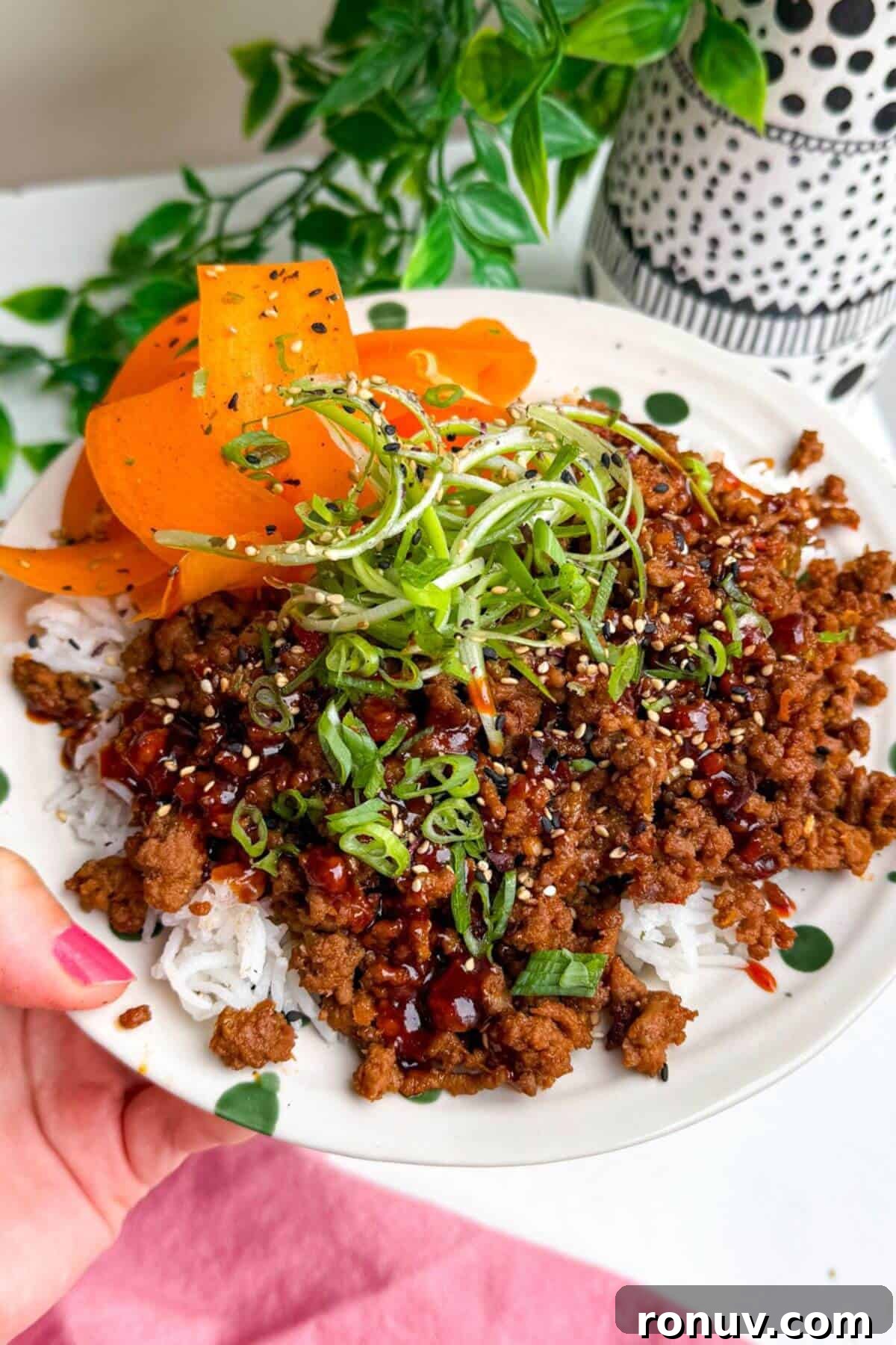 Holding sticky gochujang rice bowl.