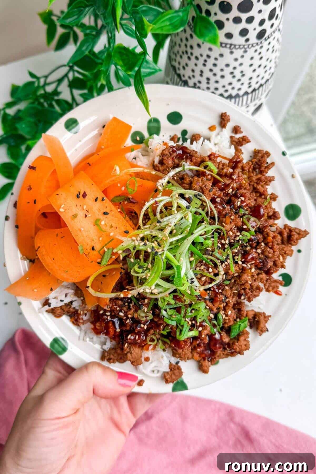 Sticky Gochujang Beef Bowl Recipe - Spicy Korean Rice Bowl 5 Holding sticky gochujang rice bowl.