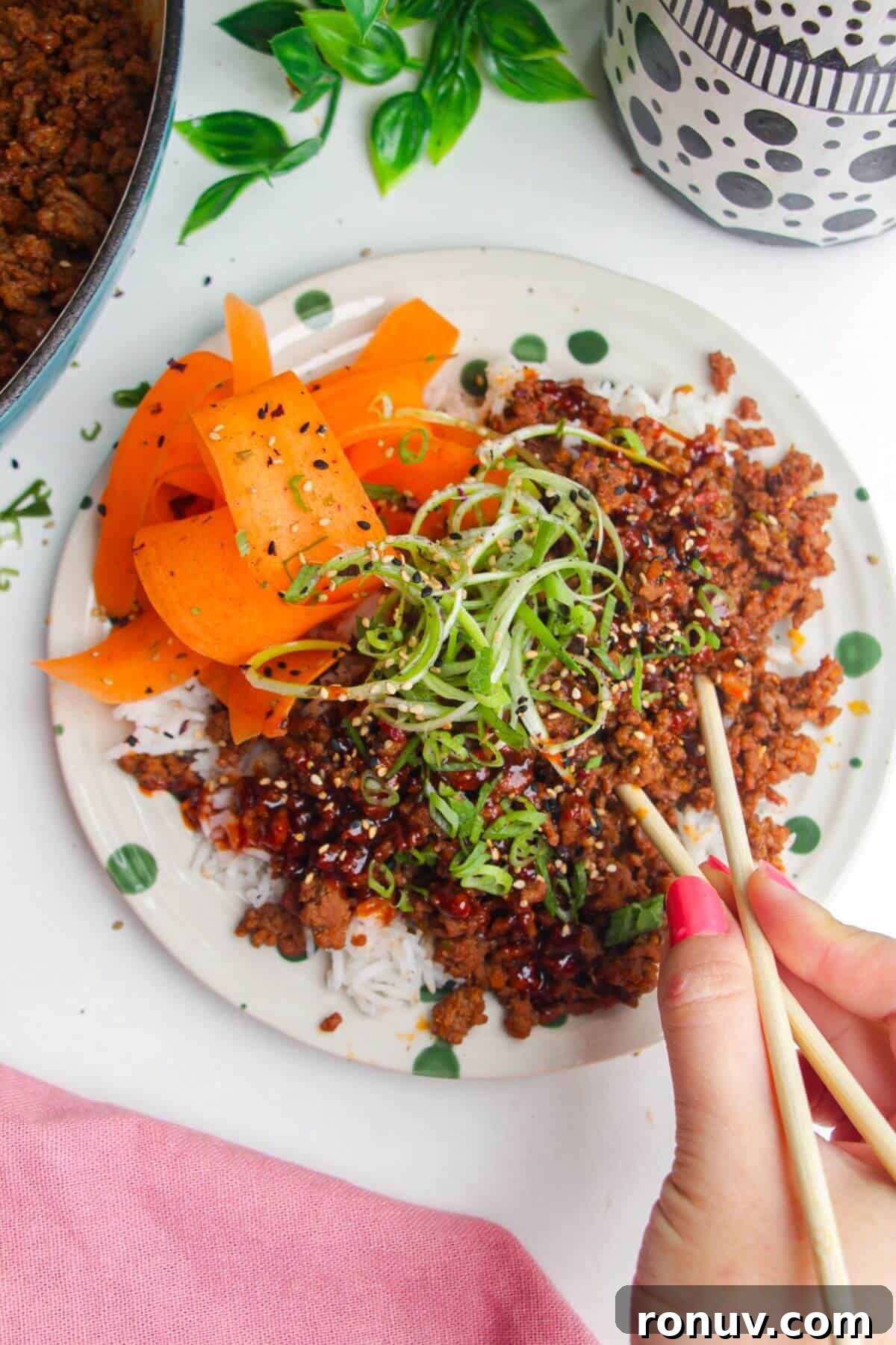 Sticky Gochujang Beef Bowl Recipe - Spicy Korean Rice Bowl 6 Using chopsticks with a sticky gochujang beef bowl.