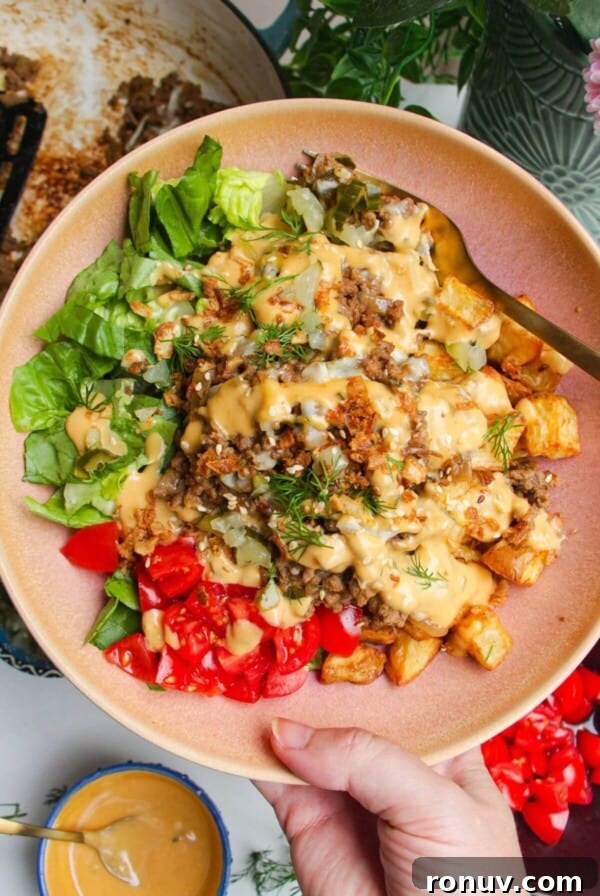 Holding loaded cheeseburger bowls drizzled with burger sauce.