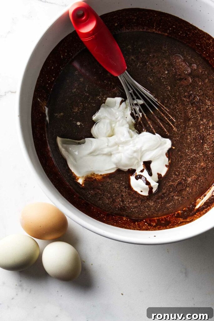 Triple Chocolate Layer Cake Recipe: Moist, Fudgy Layers 5 Mixing sour cream into chocolate cake batter.