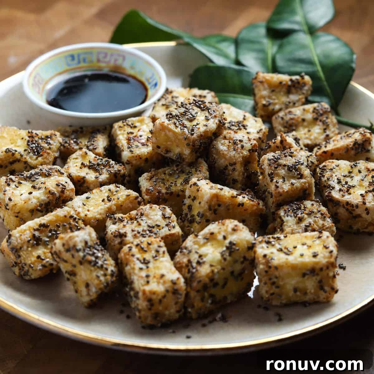 Crispy Air Fryer Tofu Recipe with Chia Seeds 3 photo of crispy air fried tofu cubes on a plate with a bowl tamari dipping sauce.