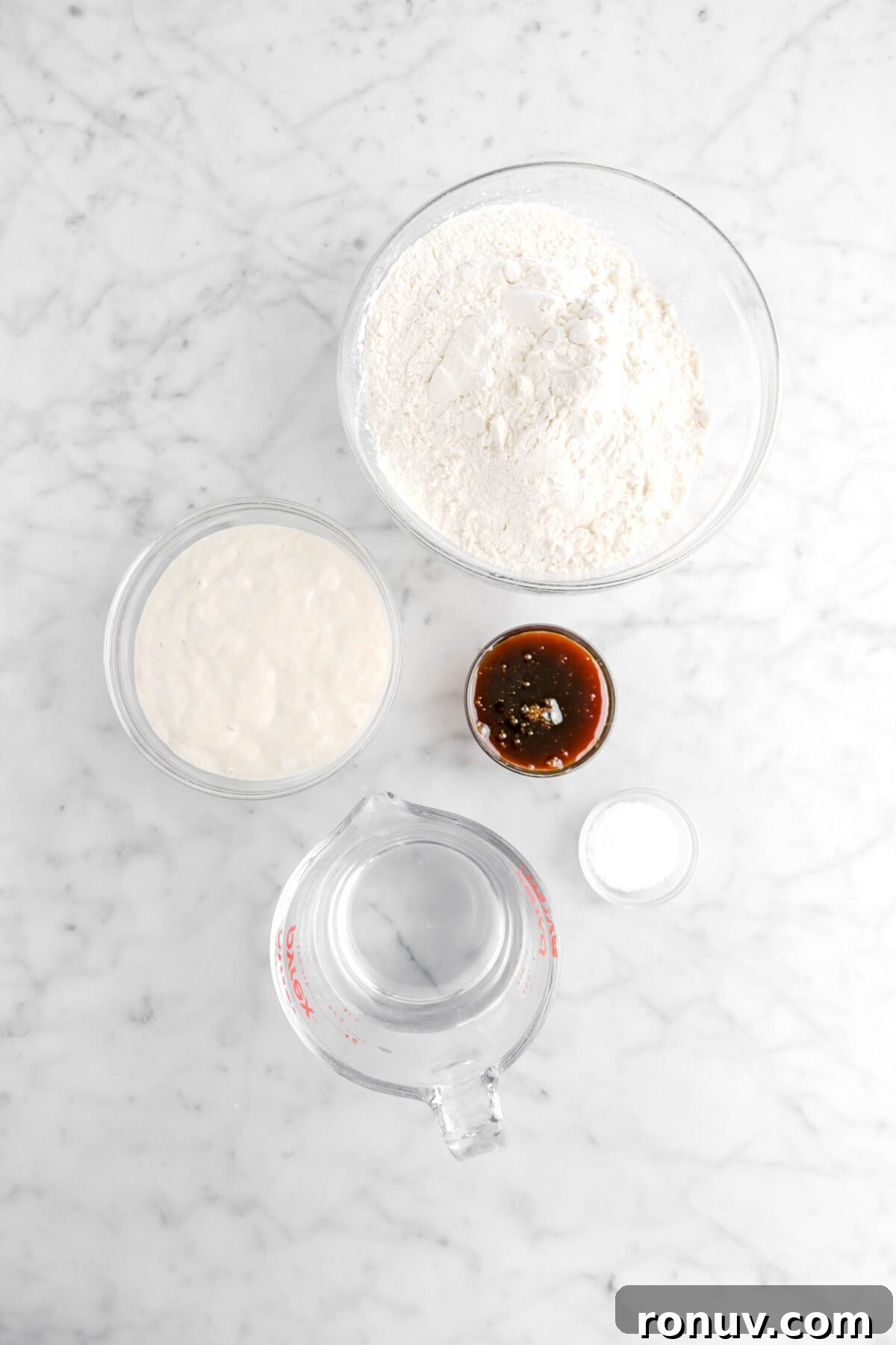 How to Make Sourdough Bagels at Home 6 flour, sourdough starter, barley malt, salt, and water on marble counter