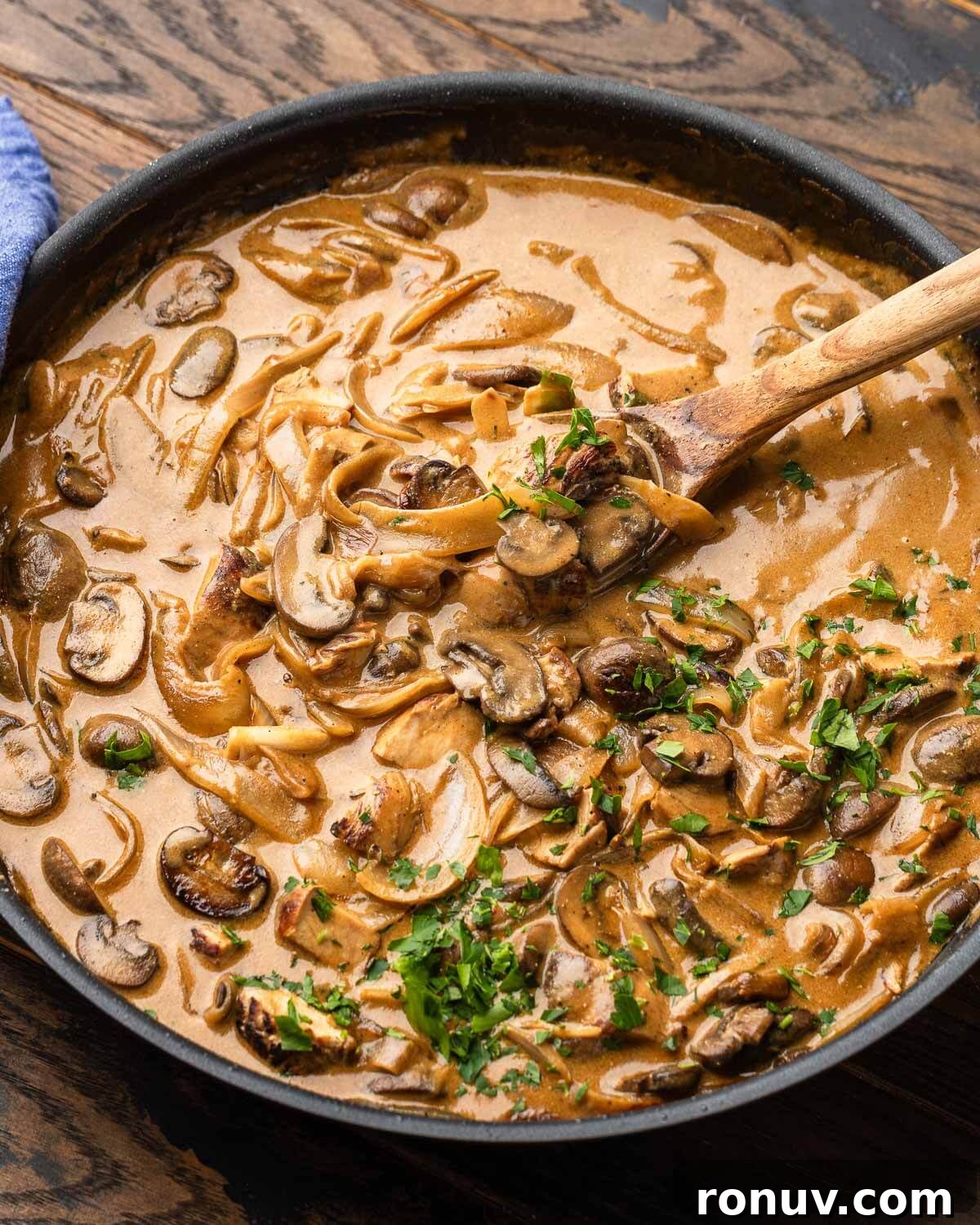 Creamy Chicken Stroganoff with Mushrooms and Egg Noodles 2 Large pan with chicken stroganoff and parsley garnish.