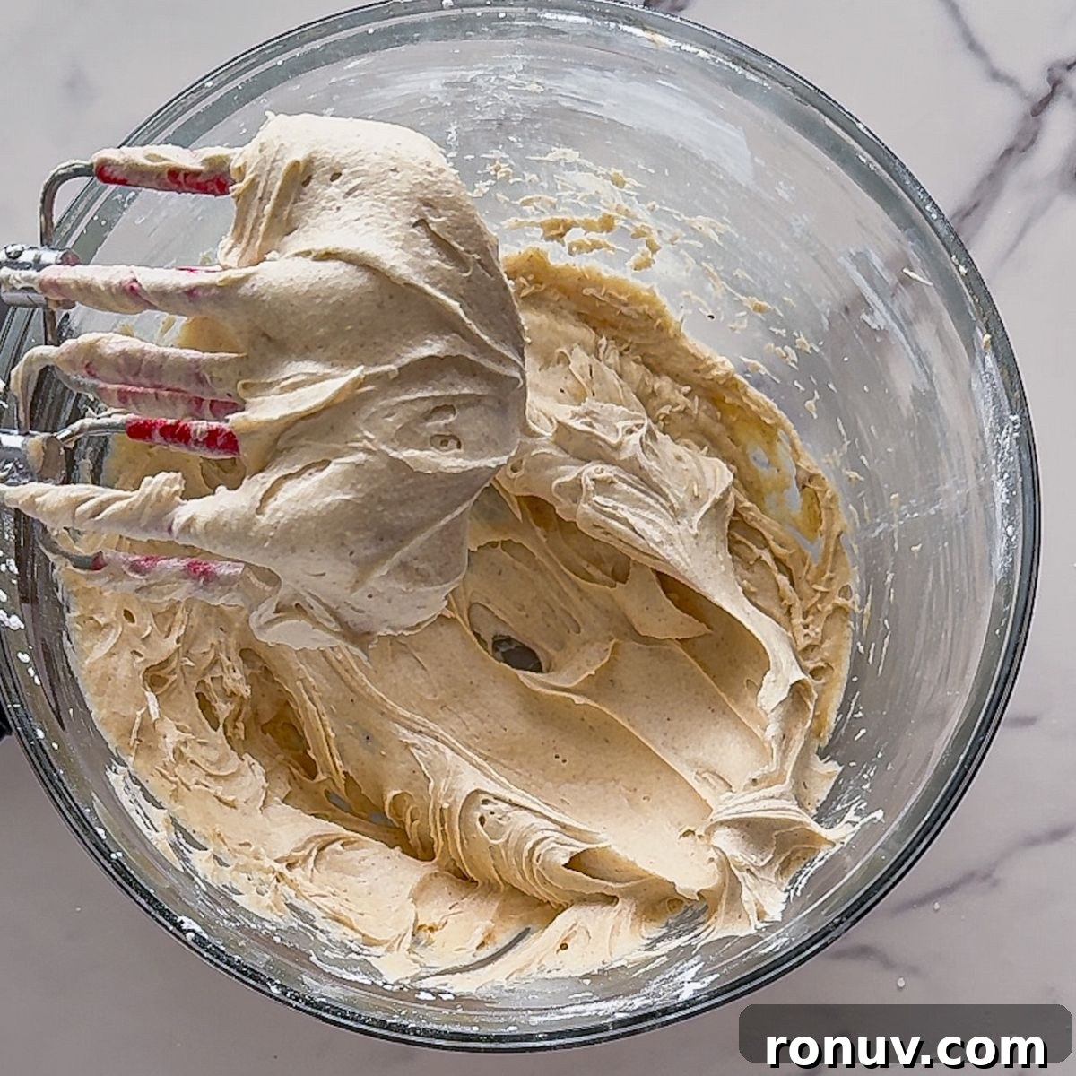 Mixing Brown Butter Cream Cheese Frosting on a cupcake.