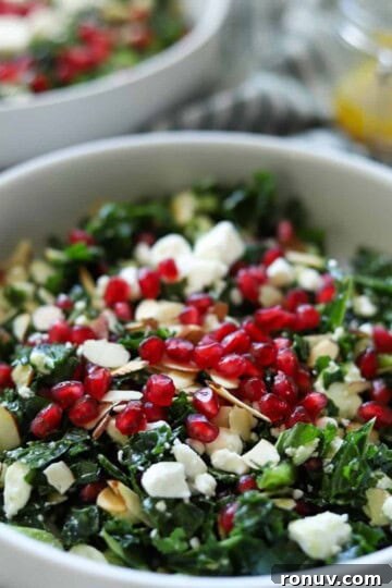 close up of kale salad topped with pomegranate seeds
