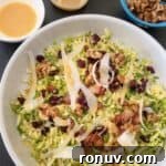 brussel sprout salad in bowl with side of spicy honey mustard and bowl of walnuts