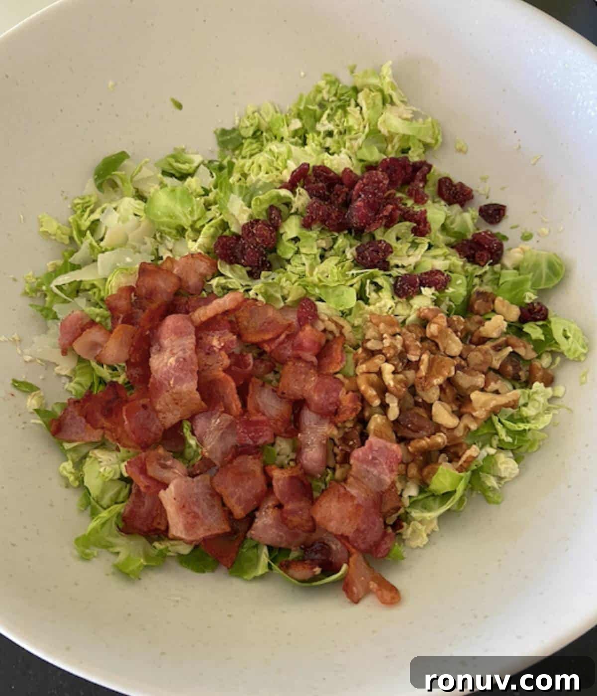 Shaved Brussels Sprouts Salad with Crispy Bacon 7 Brussel sprout salad topped with bacon, cranberries, and walnuts.