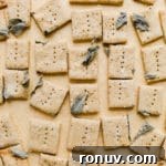 20 Creative Sides to Serve with Soup Beyond Bread 8 Crackers with pressed sage spread on a piece of parchment paper.