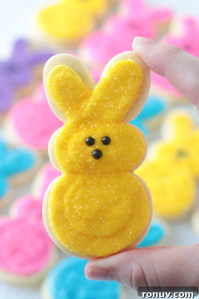 25 Easter Desserts to Impress Your Guests 6 hand holding yellow peeps bunny sugar cookie