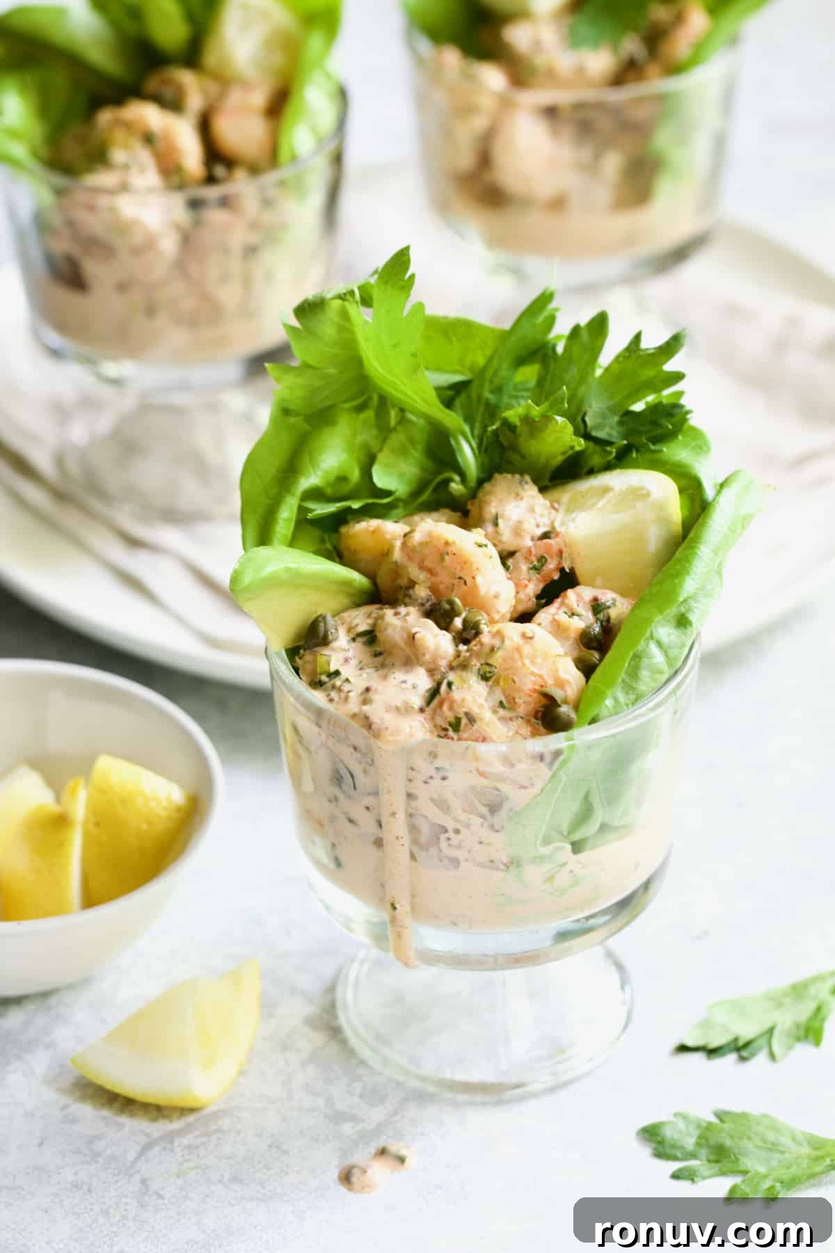 Spicy Shrimp Cocktail with Sriracha Remoulade 8 Sriracha Shrimp Remoulade Cocktail with lemon wedge and celery leaves.