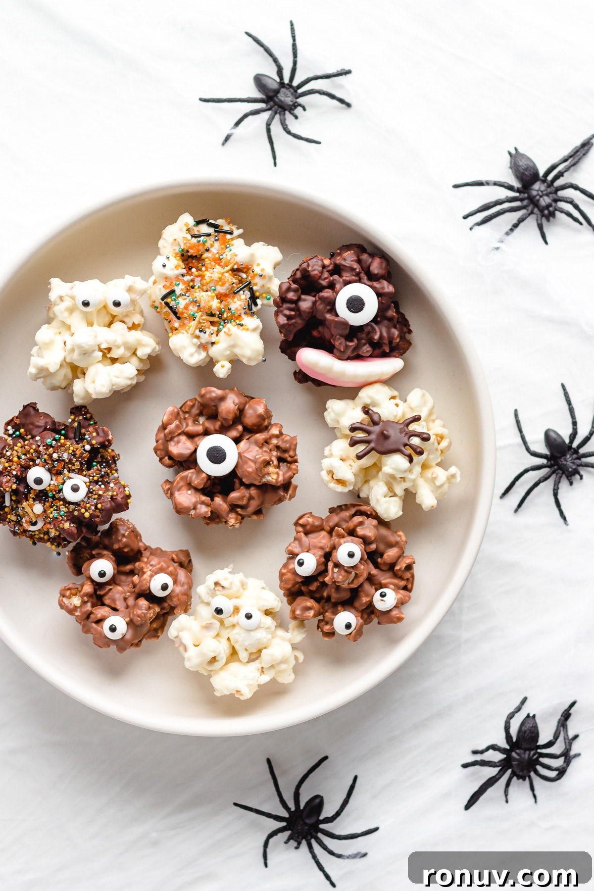 How to Make Chocolate Halloween Popcorn Balls 11 Serving platter of chocolate Halloween popcorn balls with fake spiders crawling next to it.