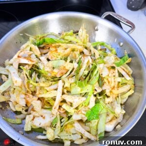 Southern Fried Cabbage Recipe with Bacon and Onions 6 Sliced cabbage in a pan on the stove.
