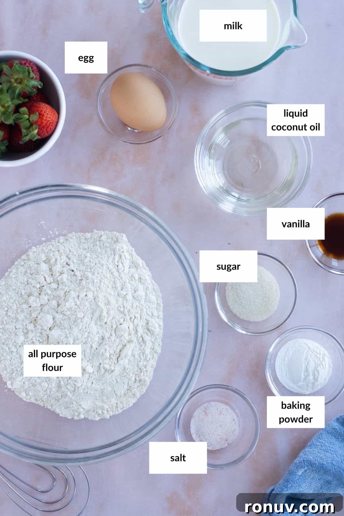 Fluffy Homemade Waffles Recipe 3 Baking ingredients on a countertop include all-purpose flour, egg, milk, liquid coconut oil, vanilla, sugar, baking powder, salt, and a bowl of strawberries.