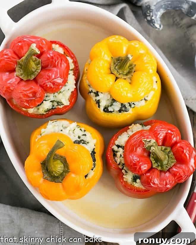 Cheese, Spinach and Rice Packed Peppers - a vegetarian stuffed pepper recipe with creamy rice, gooey nutty Gruyere, spinach and onions! Rice Packed Peppers in a casserole dish