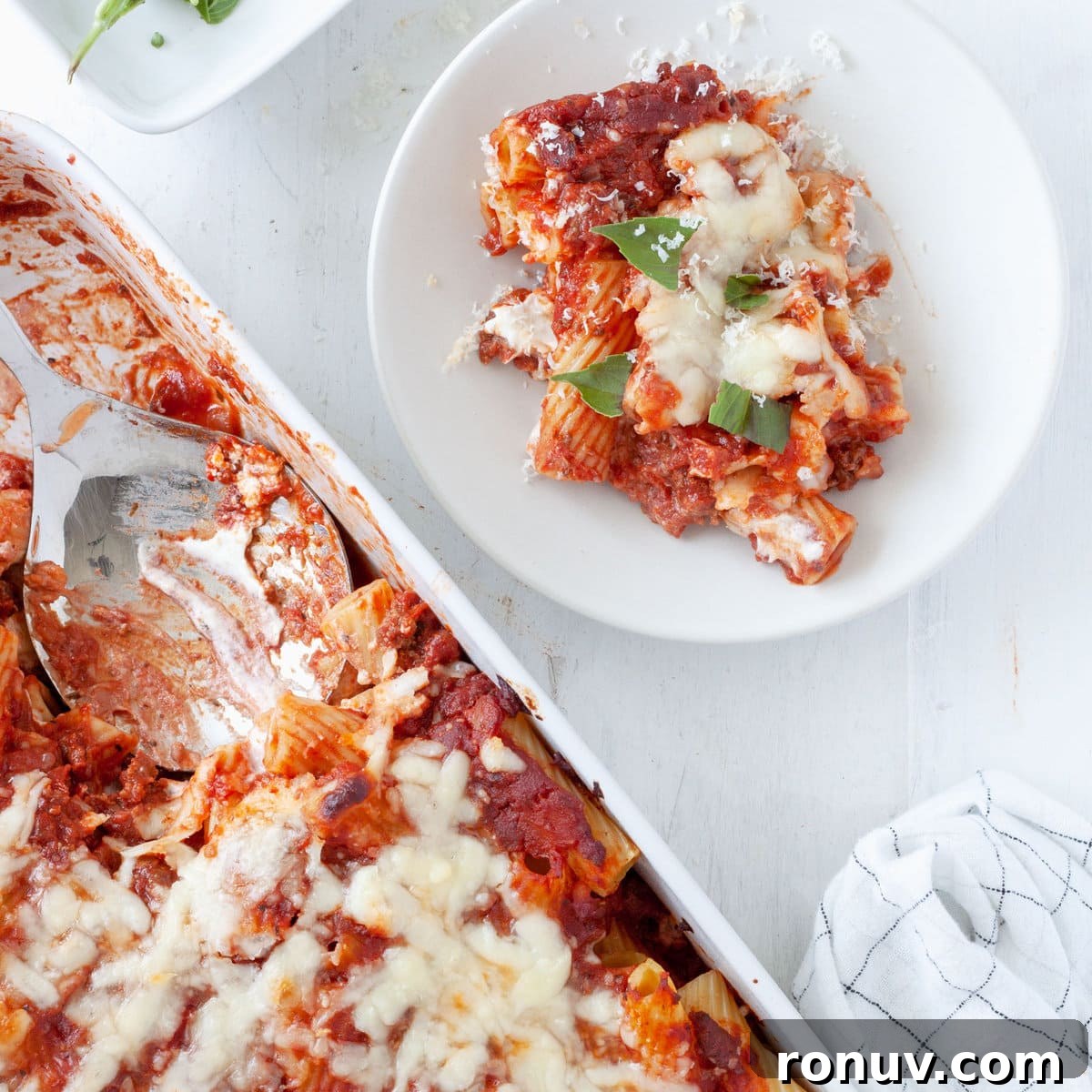 Baked Rigatoni with Cheese and Tomato Sauce 11 A scoop of rigatoni al forno taken out of a baking dish full of the baked pasta.