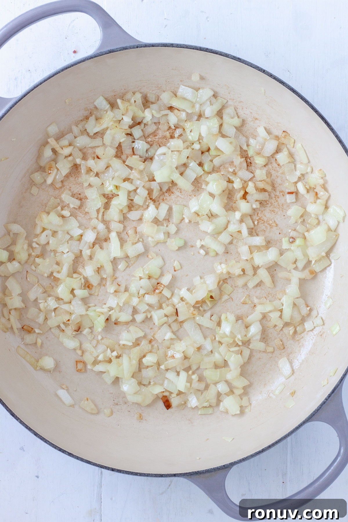 Baked Rigatoni with Cheese and Tomato Sauce 4 Onions cooking in a large skillet.