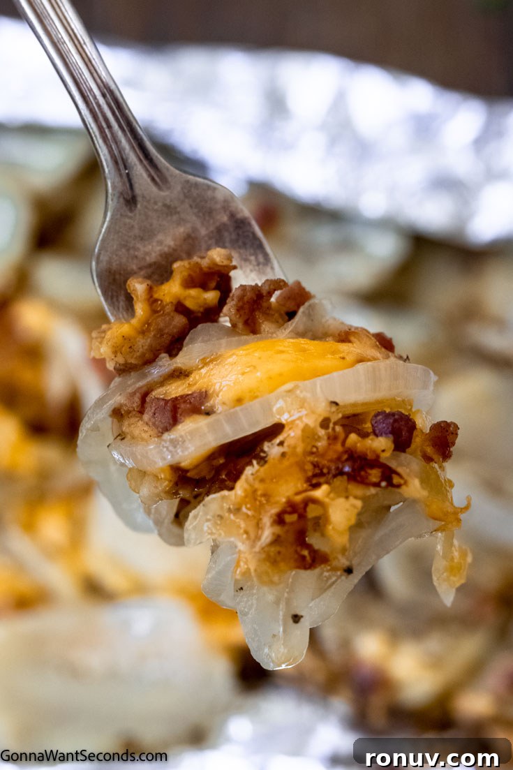 Close up of campfire potatoes with cheese and bacon campfire potatoes and onions on a fork, close up