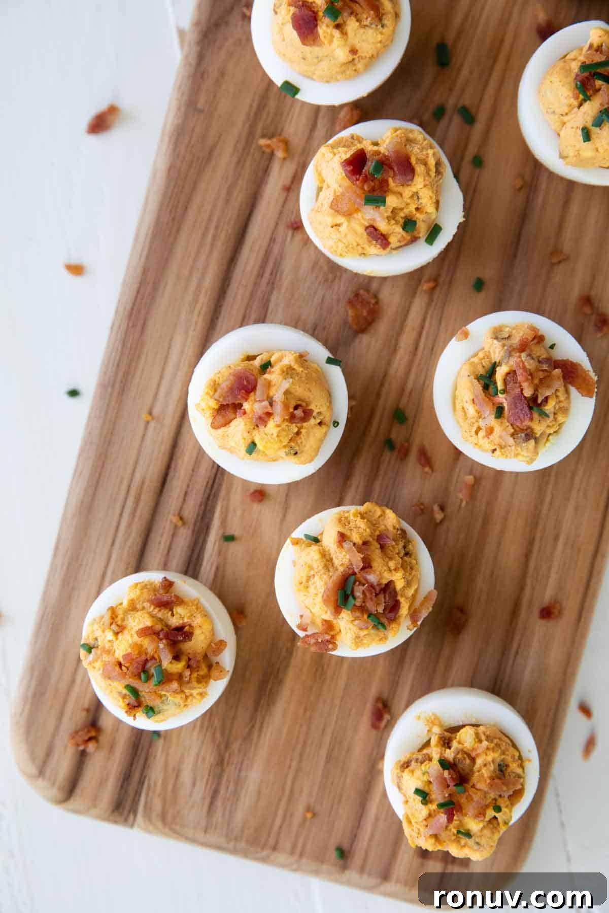 Deviled Eggs with Bacon Deviled Eggs with Bacon on a cutting board.