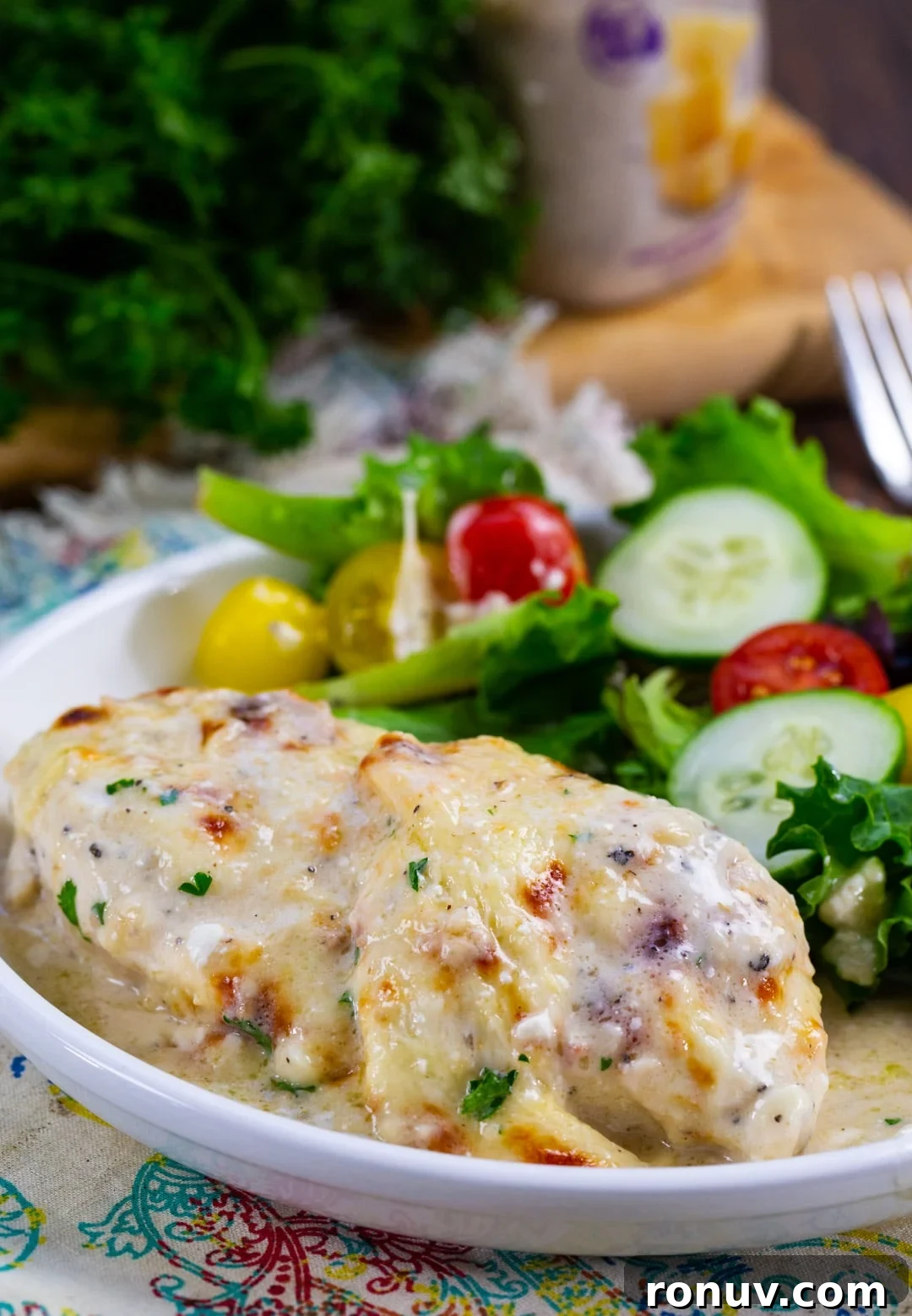 Oven-Baked Caesar Chicken Recipe with Creamy Dressing 5 Baked Caesar Chicken on plate with salad.
