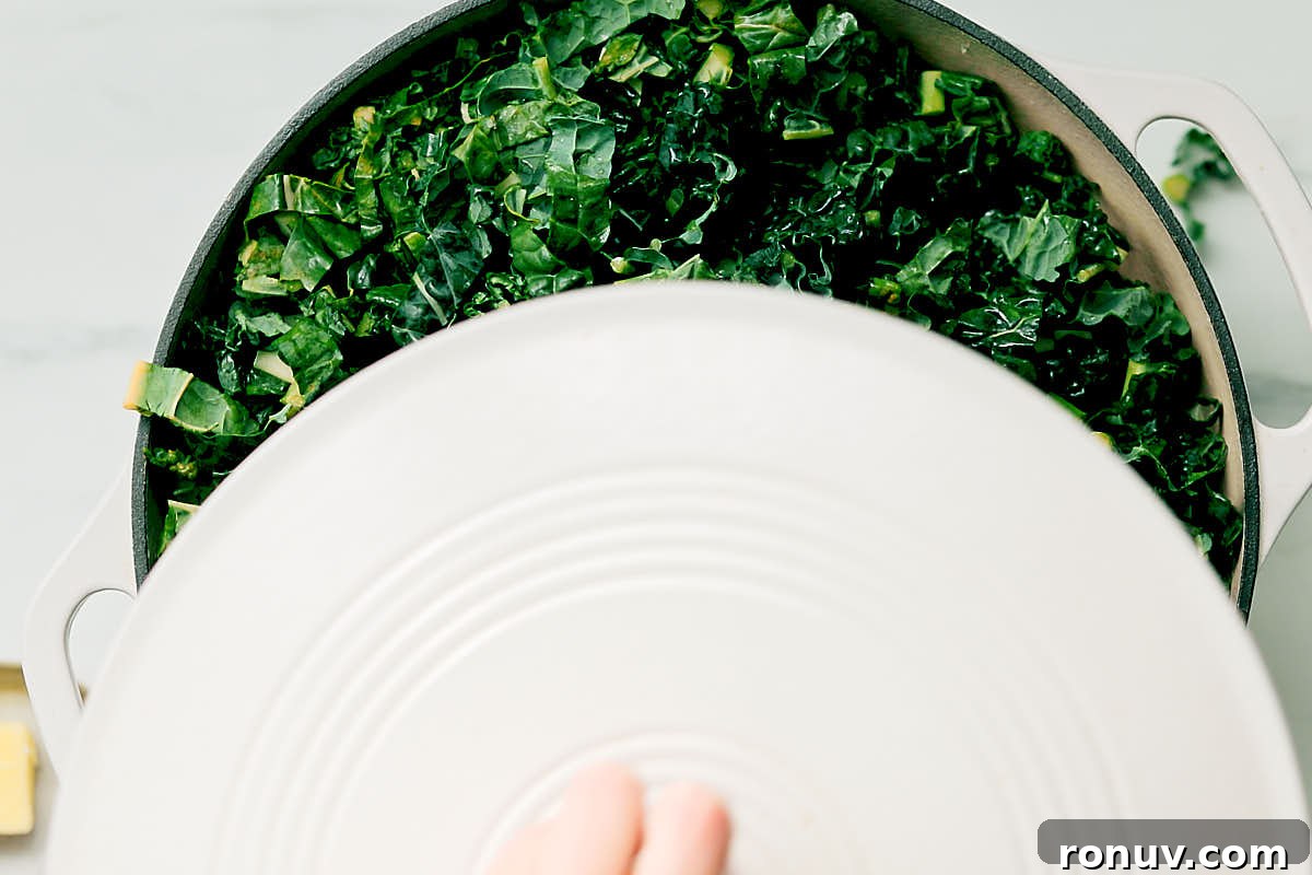 Creamed Kale Recipe: Garlic and Parmesan Side Dish 8 Fresh kale in a pan about to be covered with a lid to cook until softened.