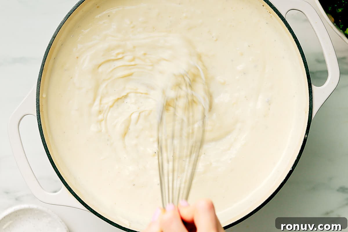Creamed Kale Recipe: Garlic and Parmesan Side Dish 10 Whisking together the milk, cheese, cream cheese mixture in a pan to make creamed kale.