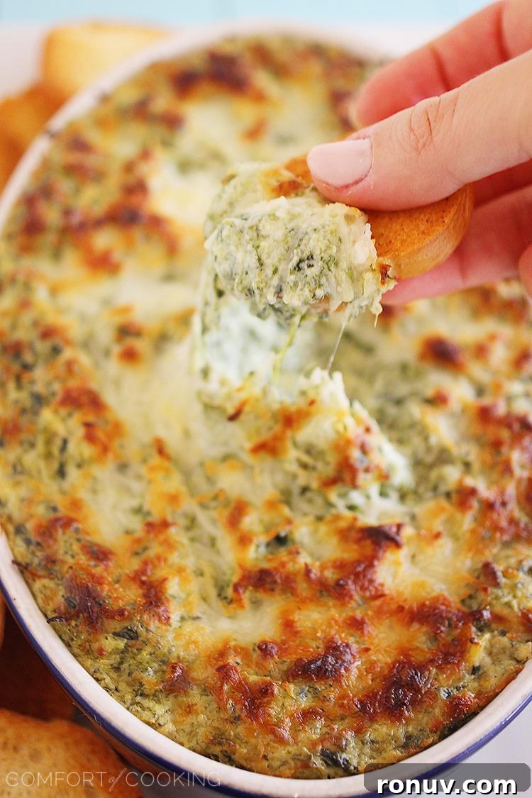 Hot Cheesy Spinach-Artichoke Dip baked and bubbling, ready to serve