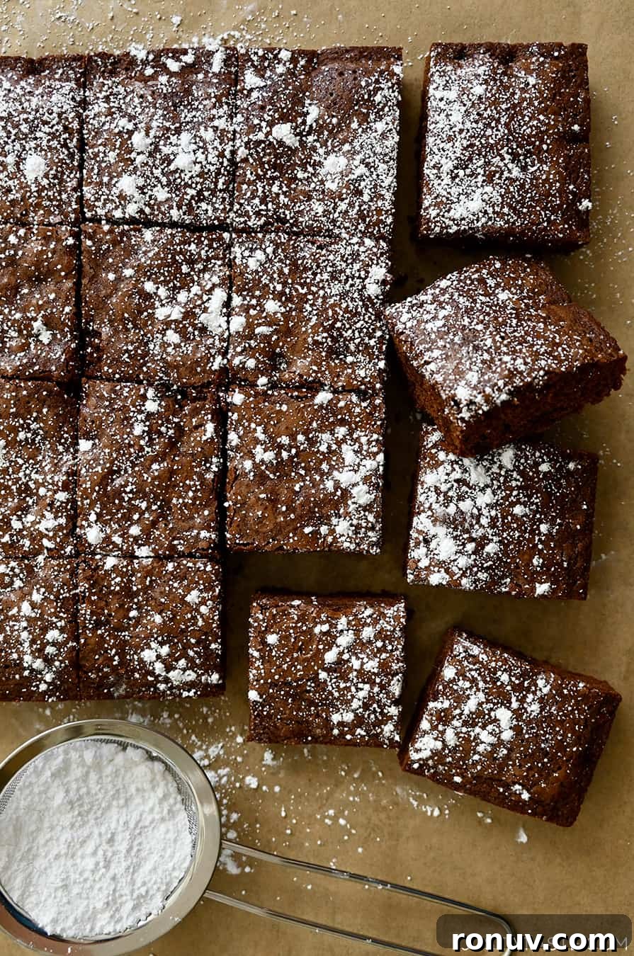 Cleanly cut brownies dusted with powdered sugar