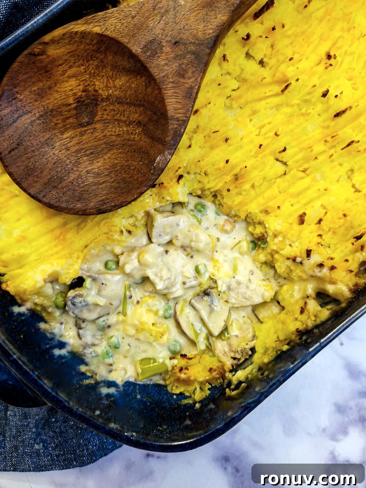Turn Leftover Chicken Into Shepherd's Pie 3 Overhead shot of chicken shepherd's pie with one corner of the potato removed to show the filling inside.