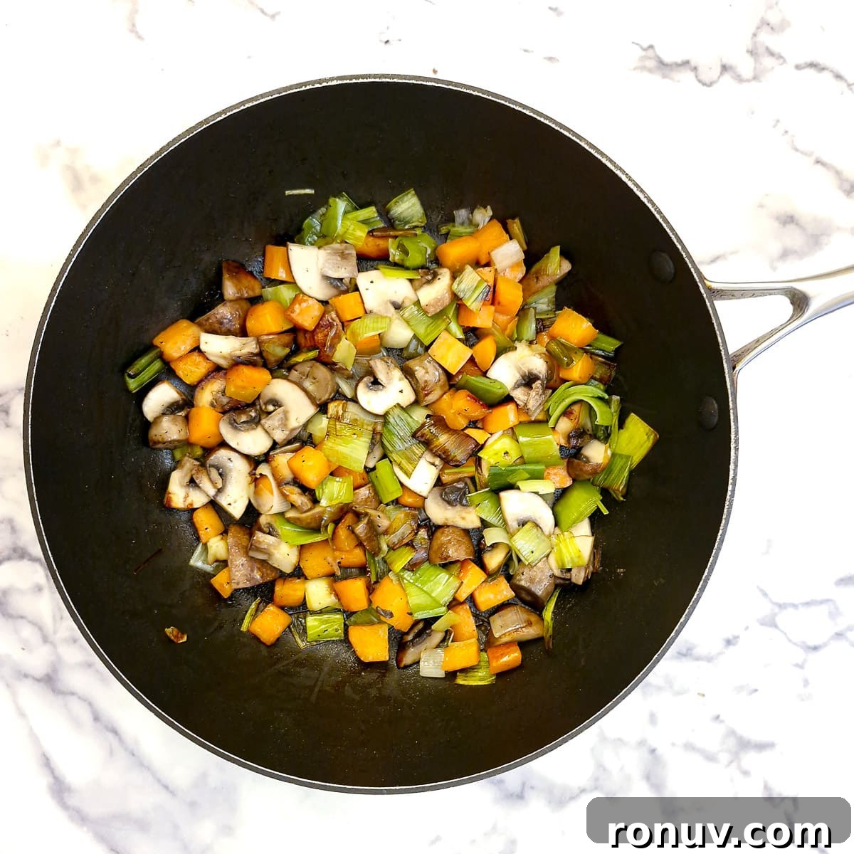 Turn Leftover Chicken Into Shepherd's Pie 6 Diced leeks, carrots and mushrooms softening in a saute pan.
