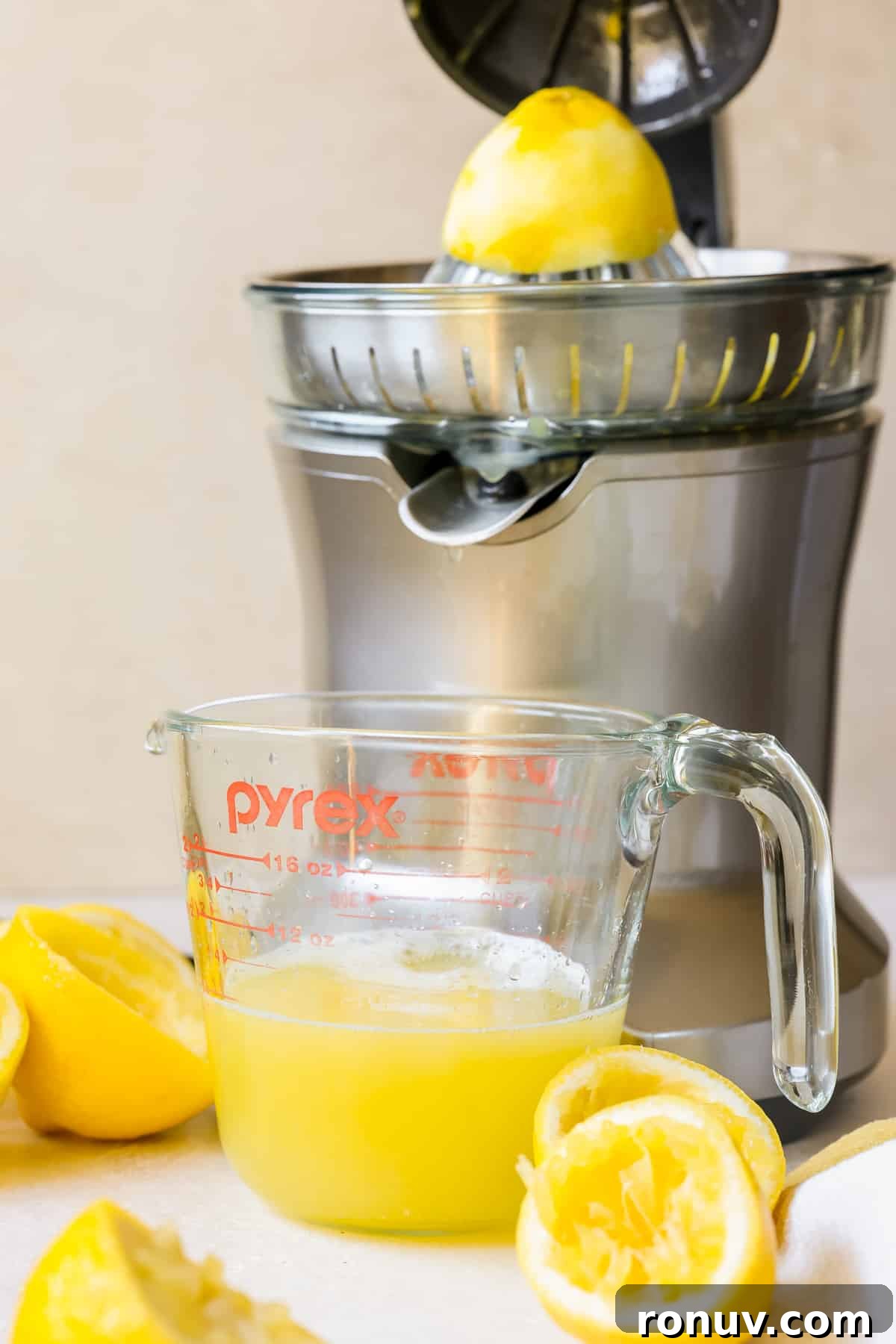Silky Homemade Lemon Curd Recipe 4 a citrus press juicing lemons into a measuring cup.