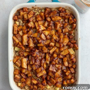 baked oatmeal topped with cinnamon apple chunks in a small teal baking dish