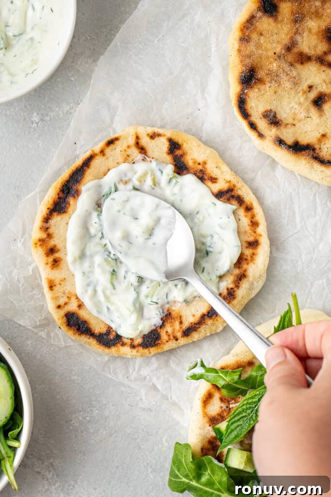Grilled Greek Lamb Pitas with Tzatziki and Feta 11 Spreading dairy free tzatziki onto the pita.