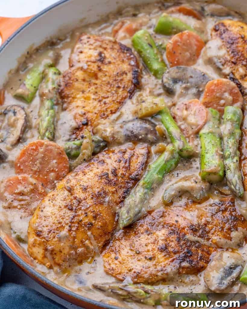 Chicken Fricassee Recipe with Mushrooms and White Wine 7 Side view of chicken in pan with asparagus, carrots, mushrooms, and celery