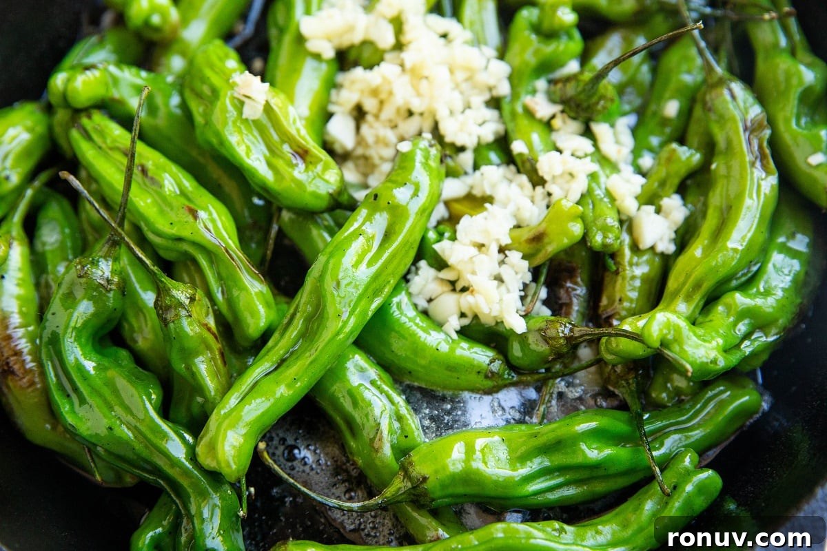 Blistered Shishito Peppers with Garlic Butter 8 skillet with cooked shishito peppers and butter and garlic