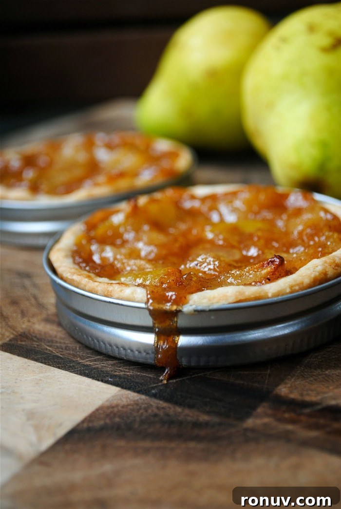 Mini Pear Tarts in a Mason Jar Lid! Mini Pear Tarts made in mason jar lids displayed on a table