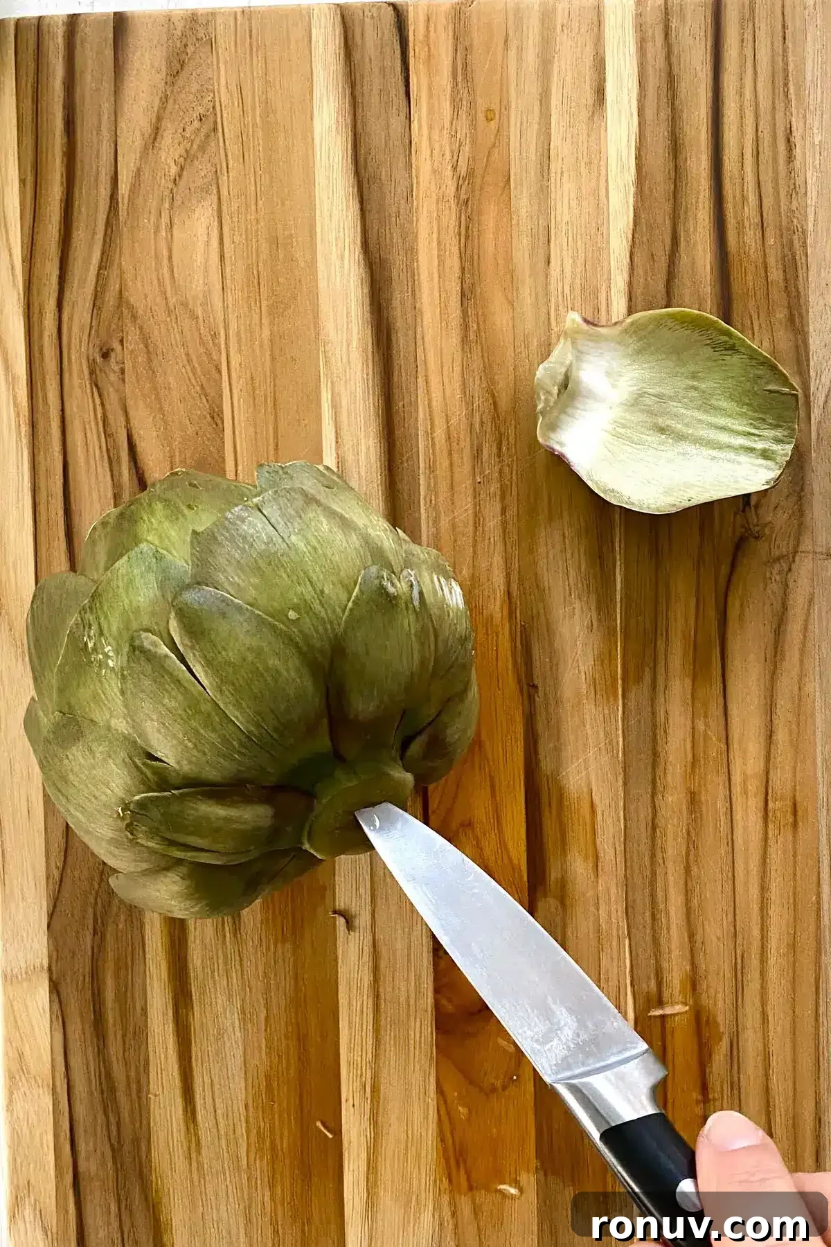 How to Cook Artichokes in the Microwave 9 cooked artichoke on a cutting board.