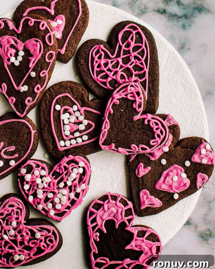 Valentine's Day Dessert Recipes for Date Night 2 Heart-shaped chocolate Valentine's cookies on a plate.
