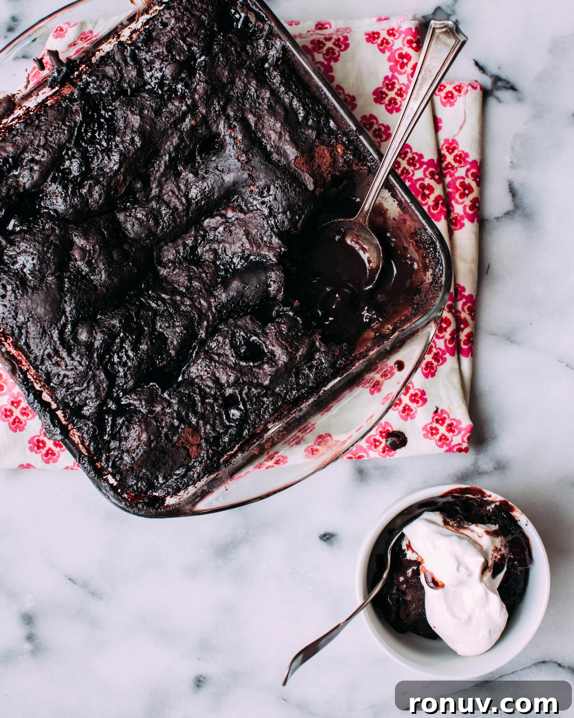 Valentine's Day Dessert Recipes for Date Night 14 Chocolate pudding cake in a baking dish with sauce underneath.