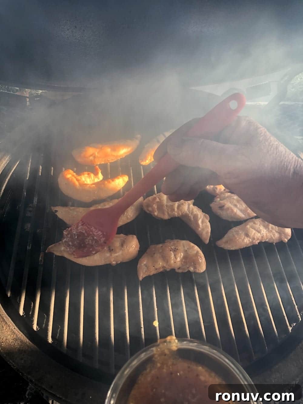 Sticky Apricot-Glazed BBQ Chicken Tenders 6 Brushing bbq sauce over chicken tenders on the grill