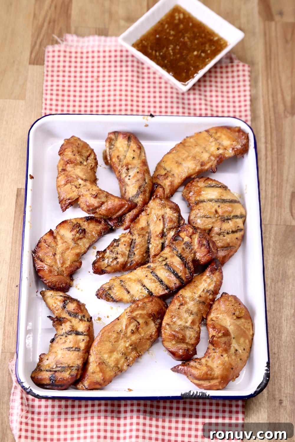 Sticky Apricot-Glazed BBQ Chicken Tenders 8 grilled chicken tenders on a platter, bowl of bbq sauce