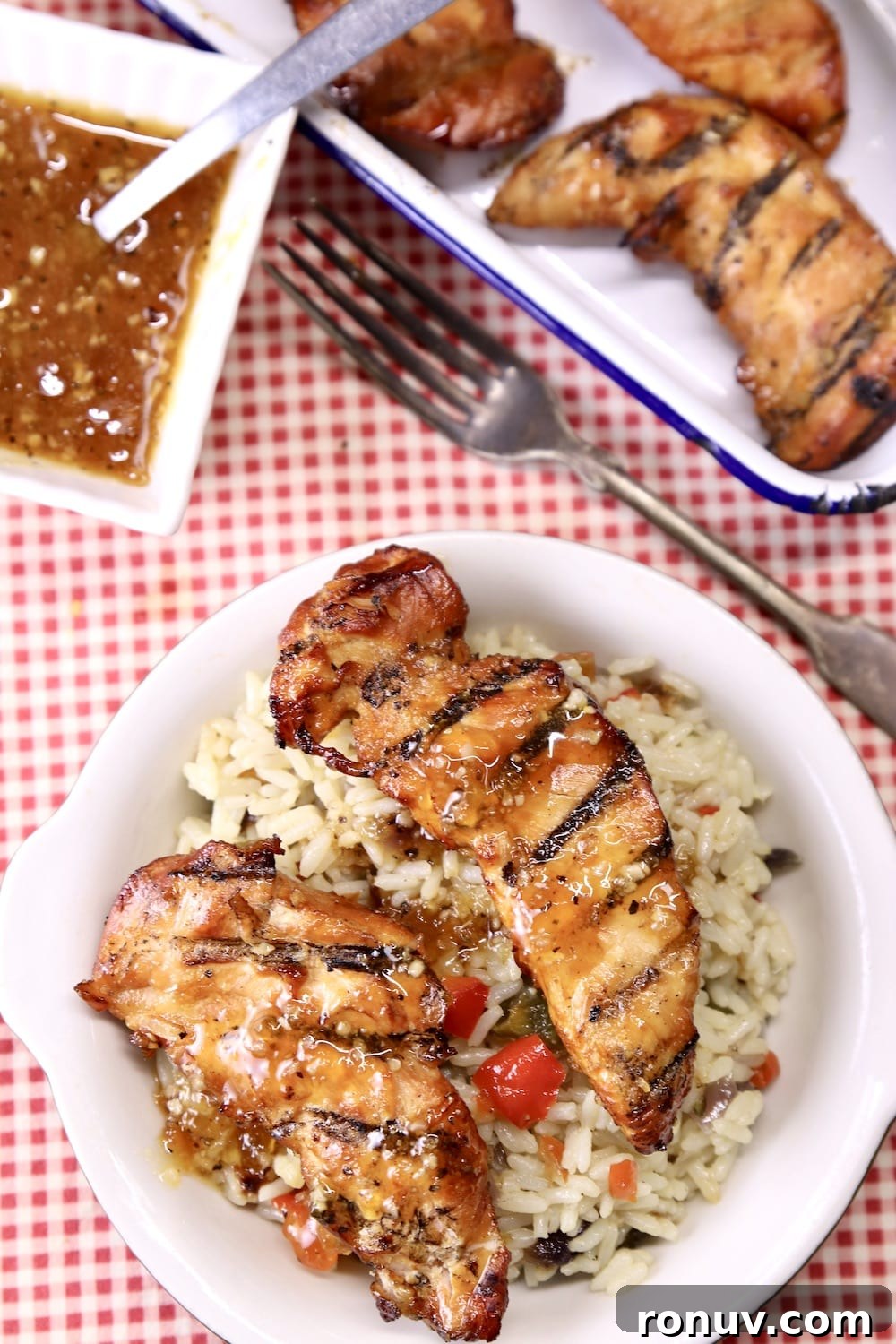 Sticky Apricot-Glazed BBQ Chicken Tenders 9 chicken tenders with rice pilaf on a plate, platter of tenders, bowl of sauce