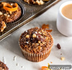 morning glory muffin with some shredded coconut and raisins next to it.