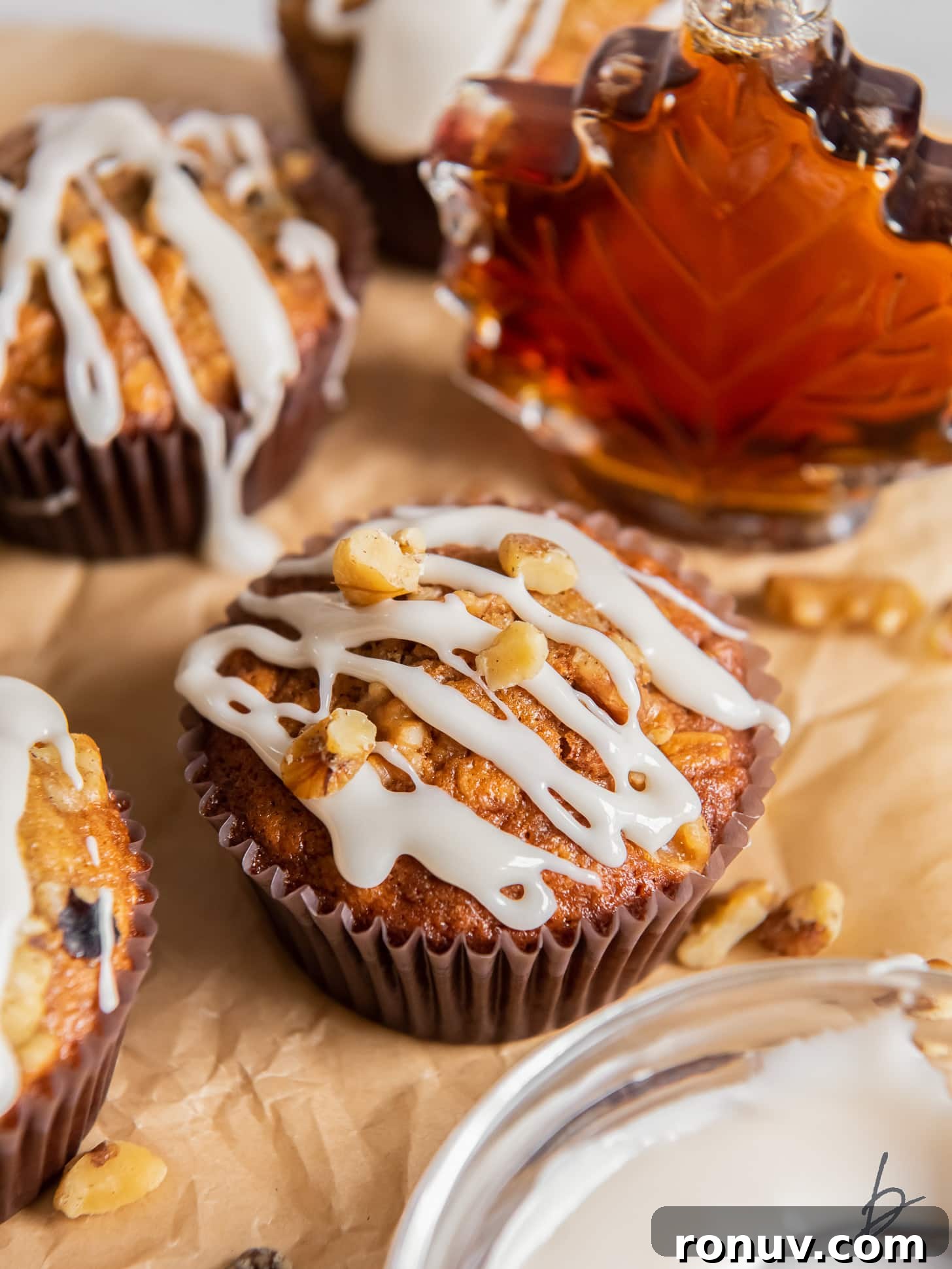 Maple Walnut Muffins Recipe 6 maple muffin with glaze drizzled on top with a few crushed walnuts.
