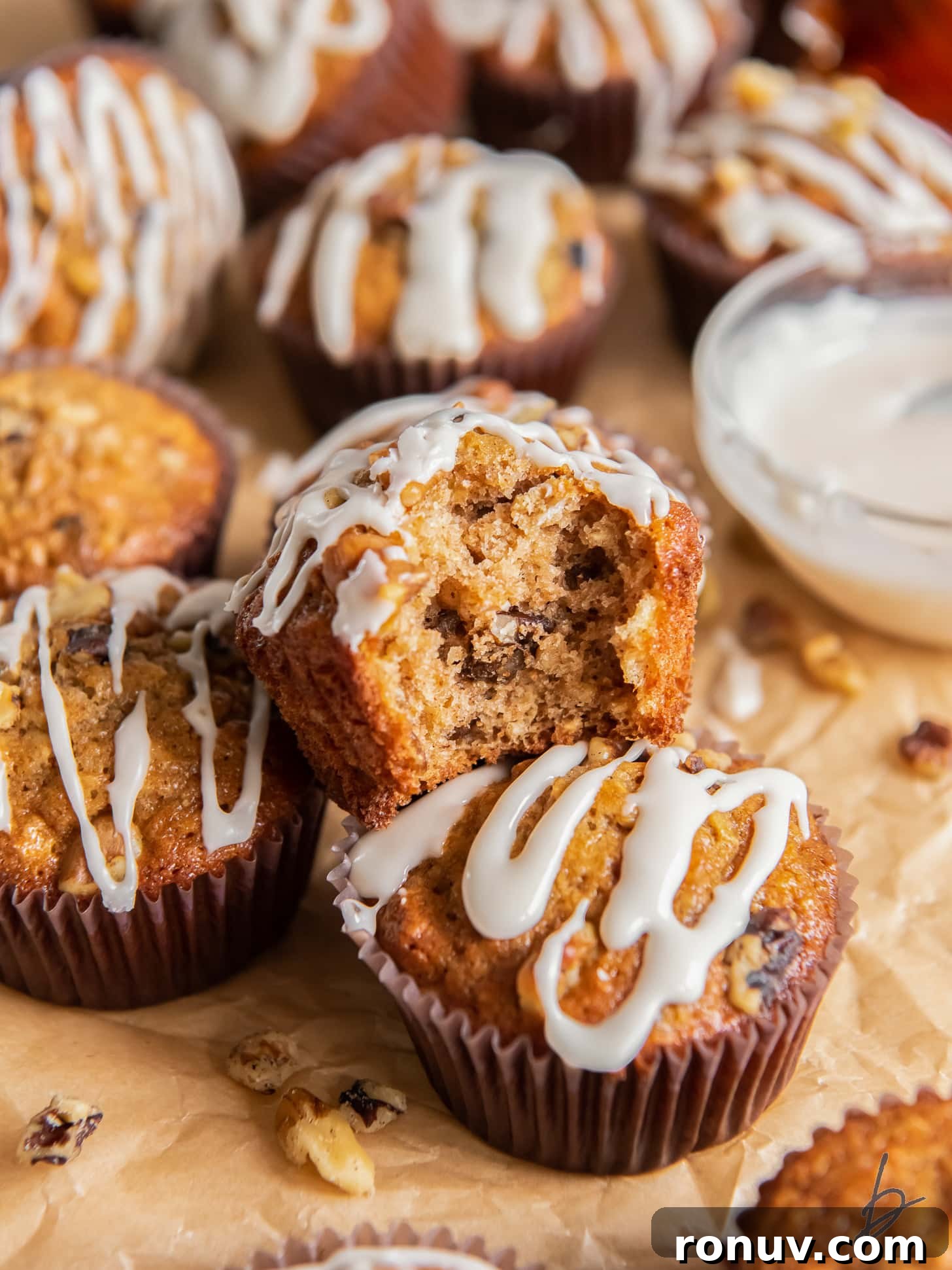 Maple Walnut Muffins Recipe 7 maple muffin with a bite on top of two more muffins with glaze.