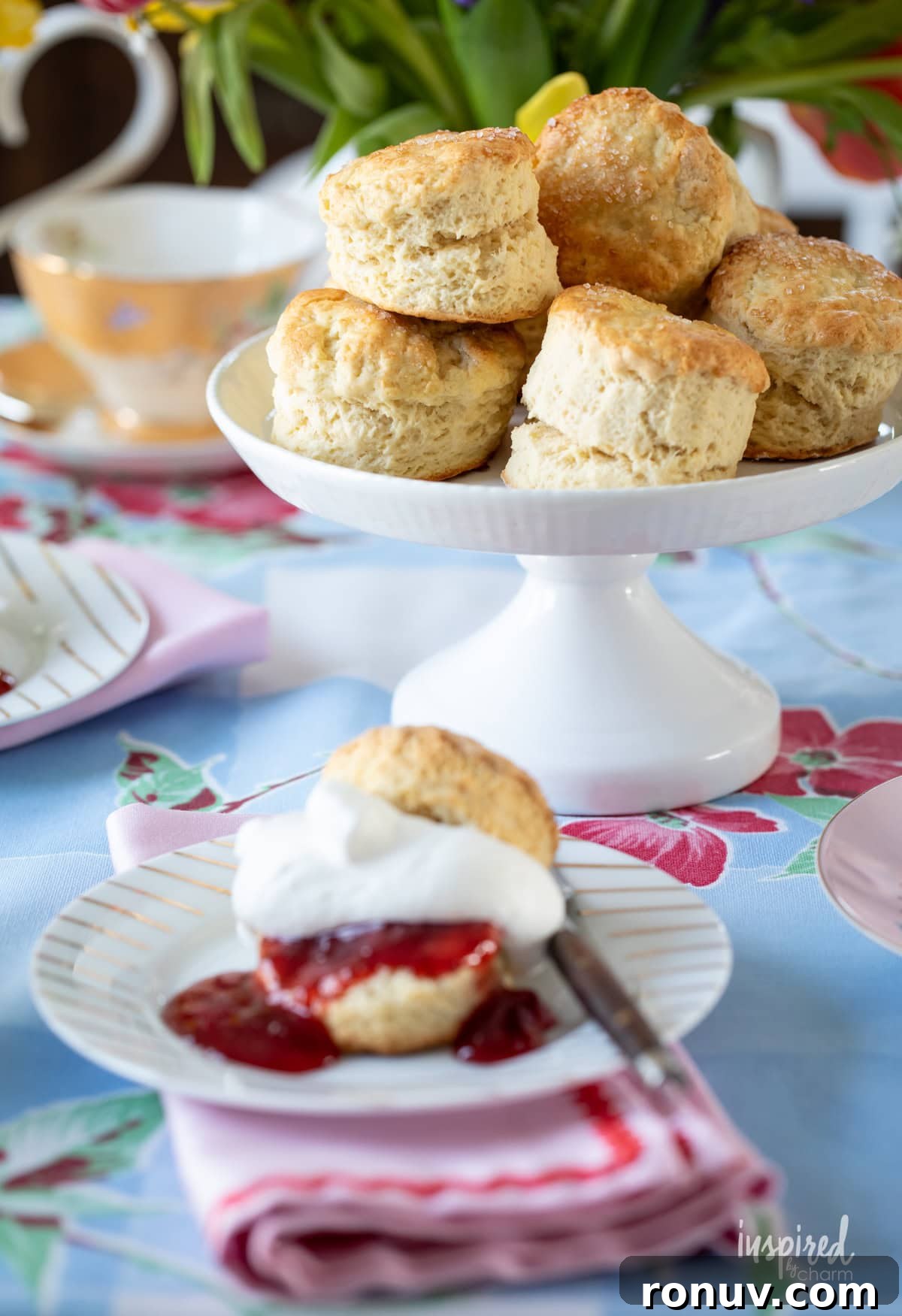 Classic Buttery Homemade Scones Recipe 15 cake stand filled with homemade scones with one served on a small plate.
