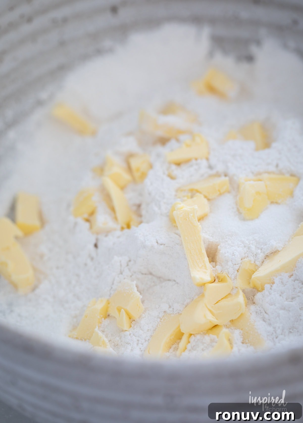 Classic Buttery Homemade Scones Recipe 8 cut up butter in flour in a bowl for scones.