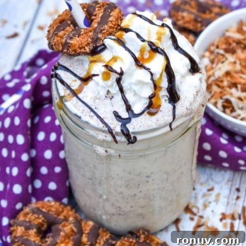 a samoa cookie milkshake in a small glass jar on a wooden table