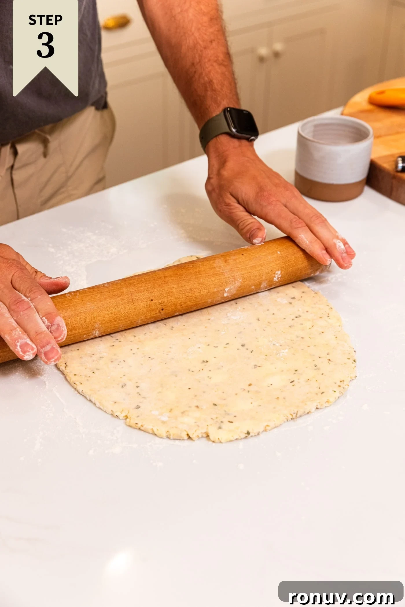 Fresh Tomato Galette Recipe with Basil 9 Hands holding wooden rolling pin rolling out dough on a white surface.