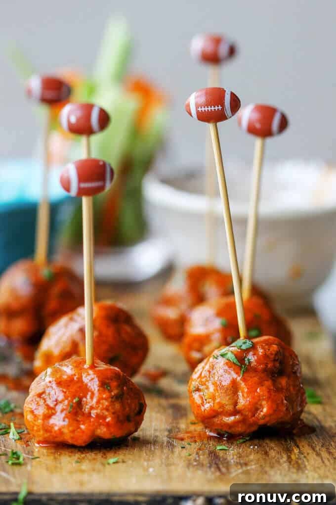 Buffalo Turkey Meatballs are a perfect appetizer for the Big Game. They're also a lighter alternative to a traditional chicken buffalo wings, not only because they have less fat, but also because they're baked, not fried. Not to mention they're also super easy to make. Buffalo Turkey Meatballs on a board with football sticks